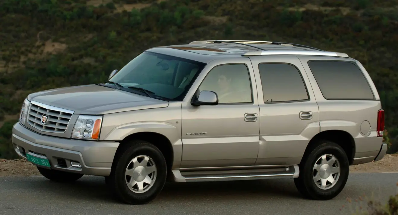 Cadillac Escalade 2002  dourado de lateral andando na estrada