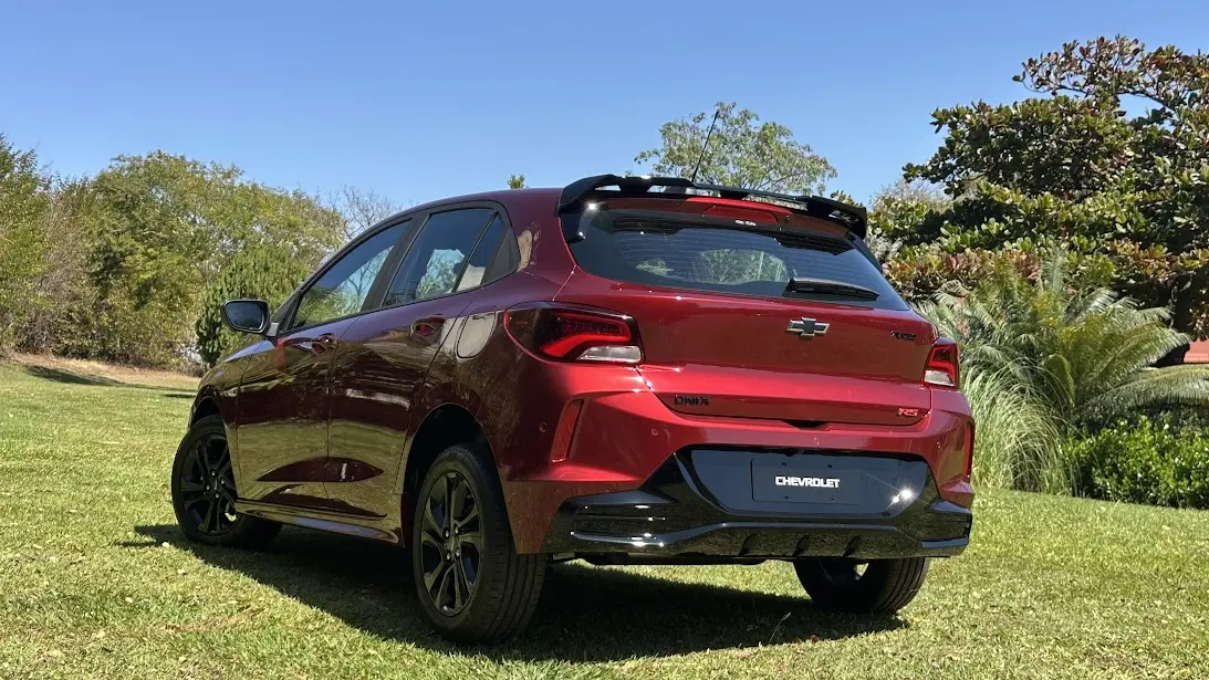Chevrolet Onix RS vermelho 2026 de traseira parado na grama