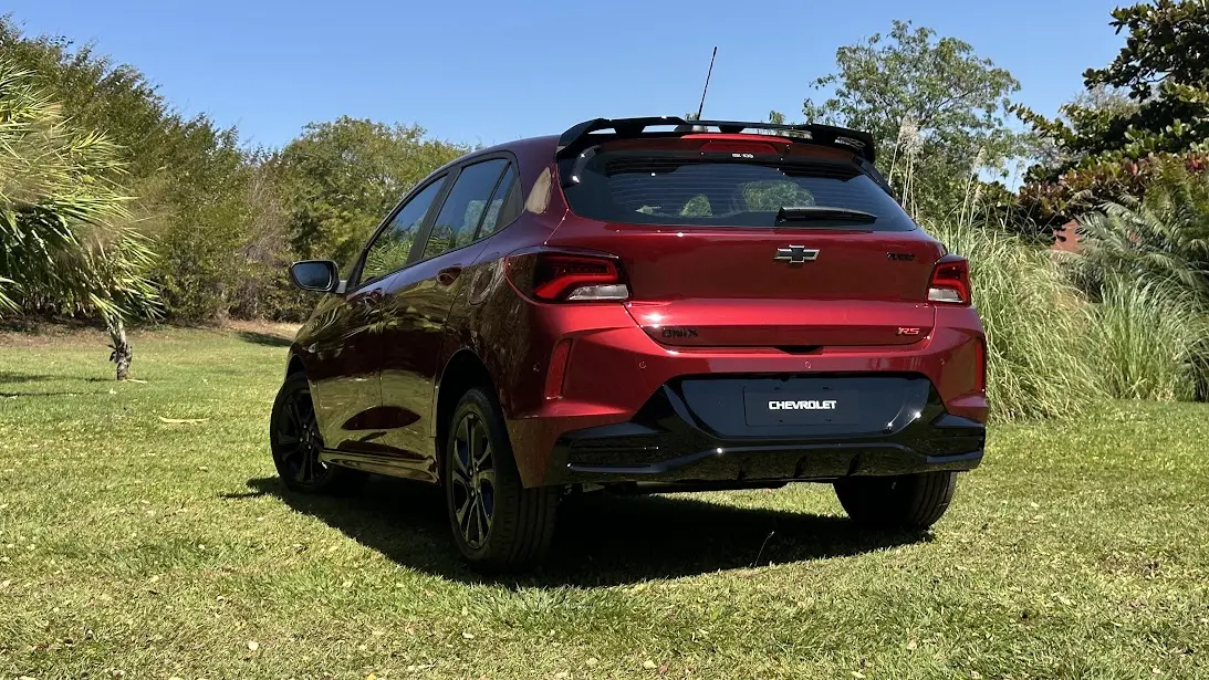 Chevrolet Onix RS vermelho 2026 de traseira parado na grama