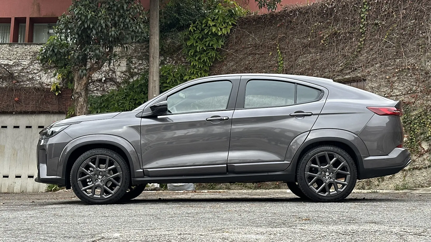 Fiat Fastback Impetus Hybrid cinza parado de  lateral com muro ao fundo