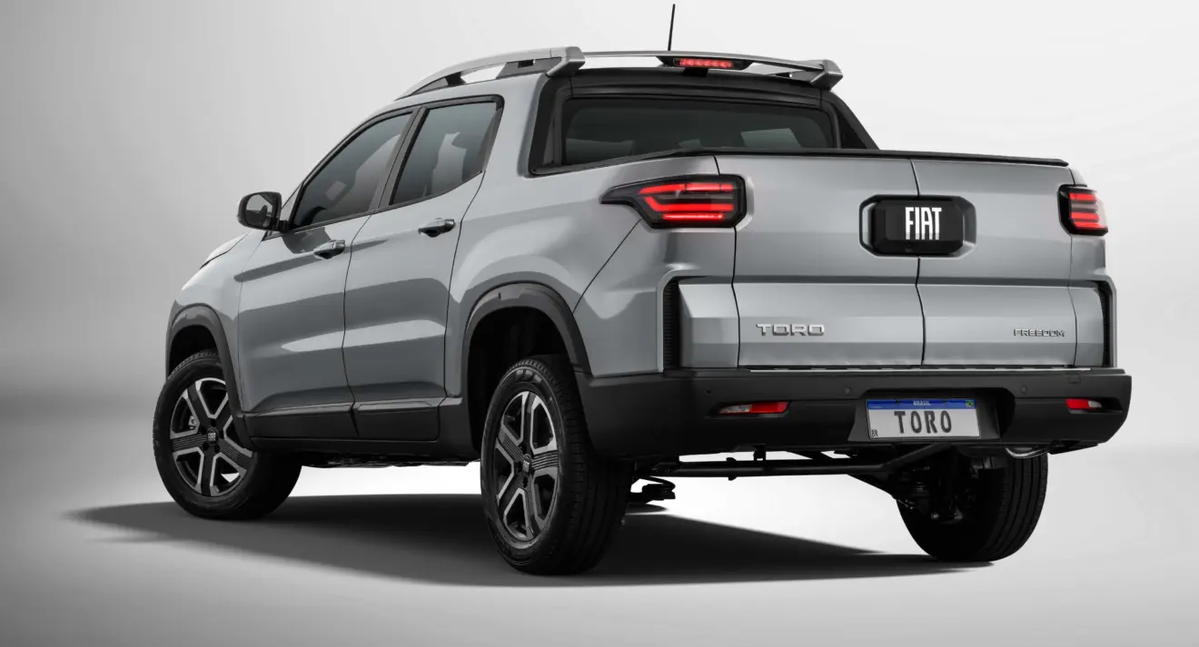 Fiat Toro Freedom 2026 prata parada de traseira com fundo neutro