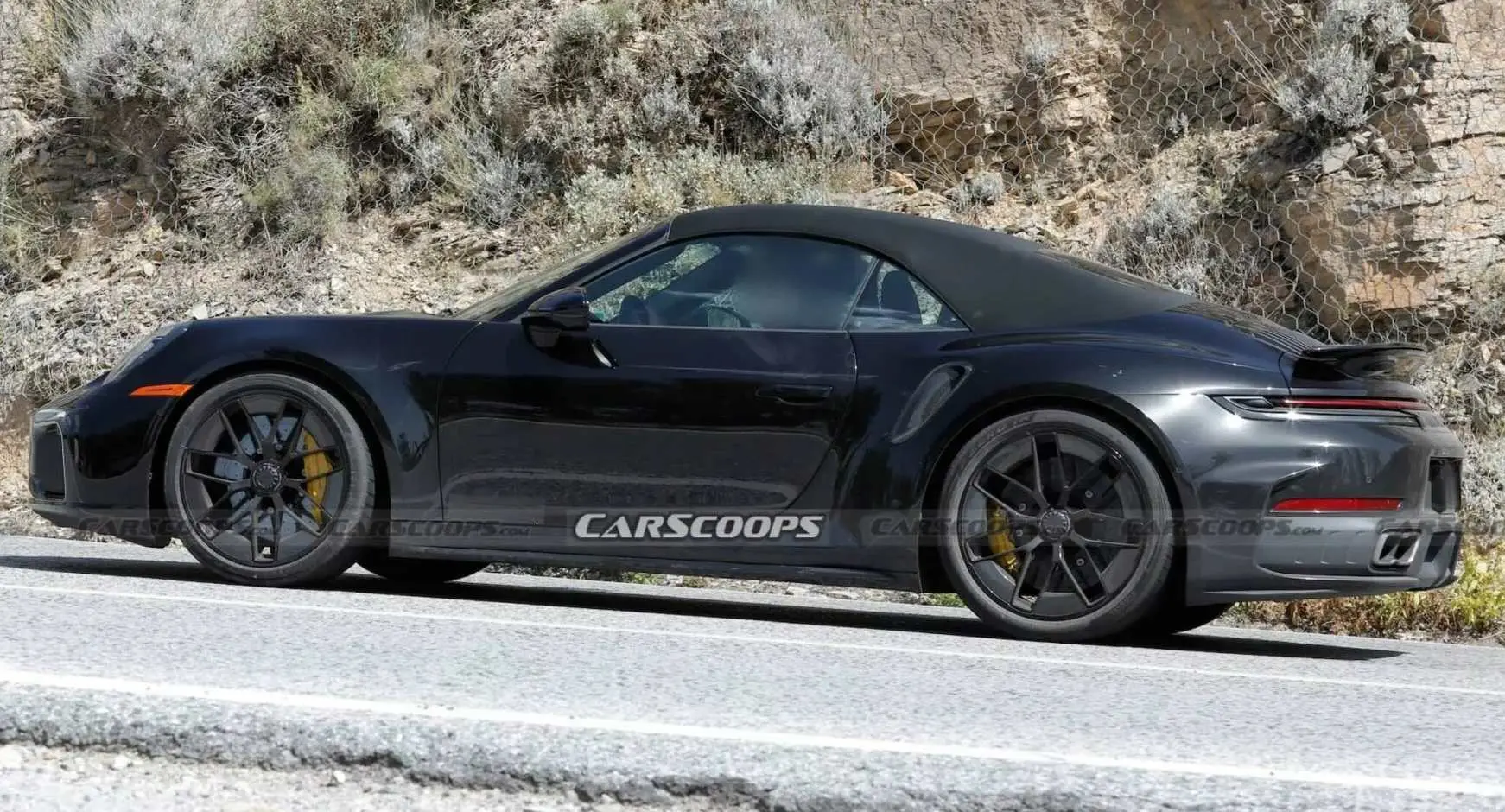 Porsche 911 Turbo conversível híbrido de lateral andando na estrada