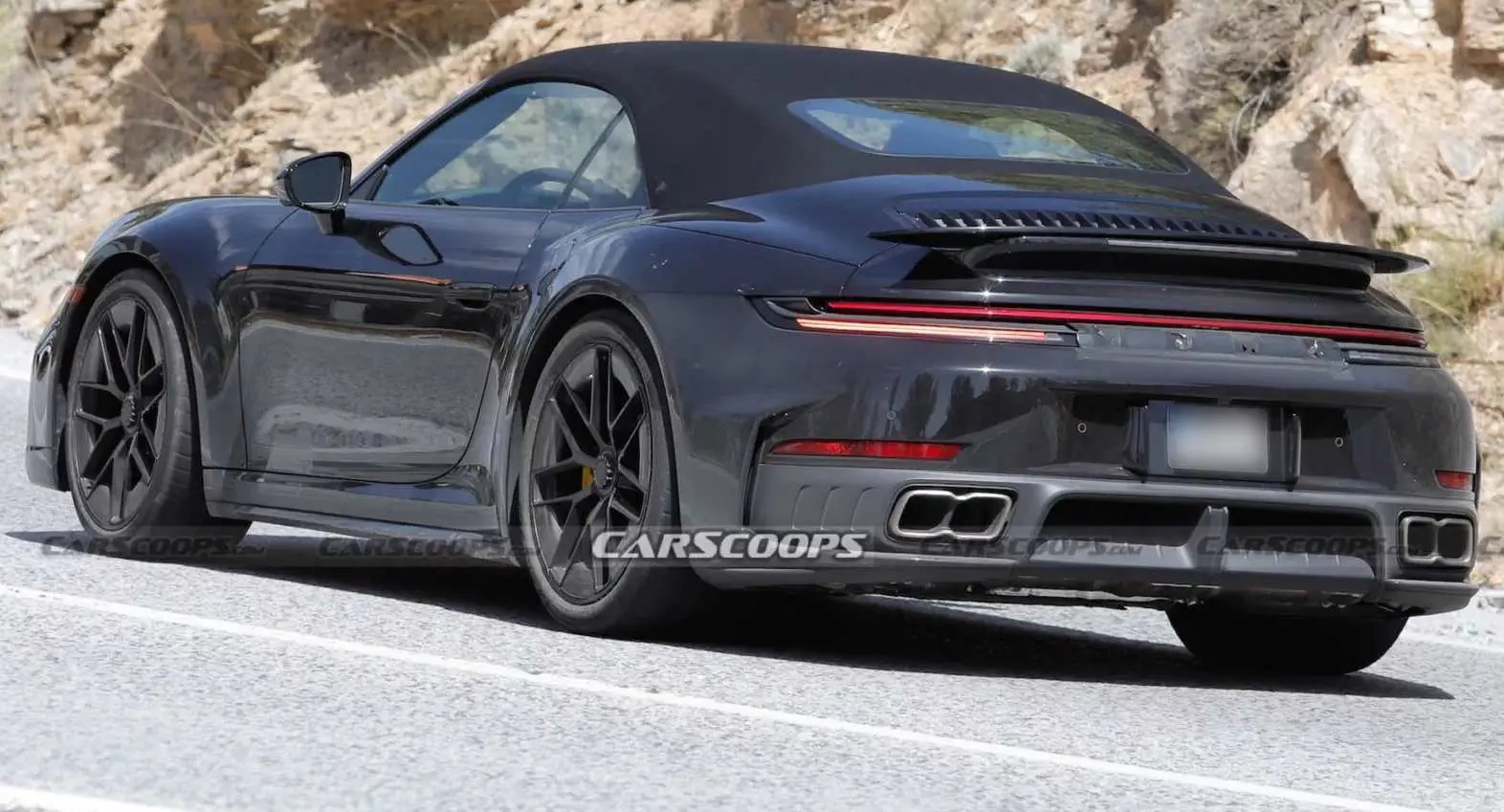 Porsche 911 Turbo conversível híbrido de traseira andando na estrada