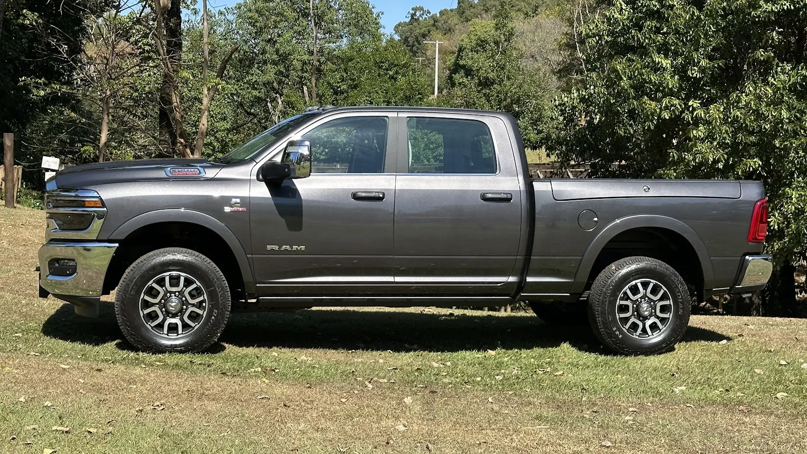 Ram 3500 Limited Longhorn marrom parada de lateral na grama com árvores ao fundo