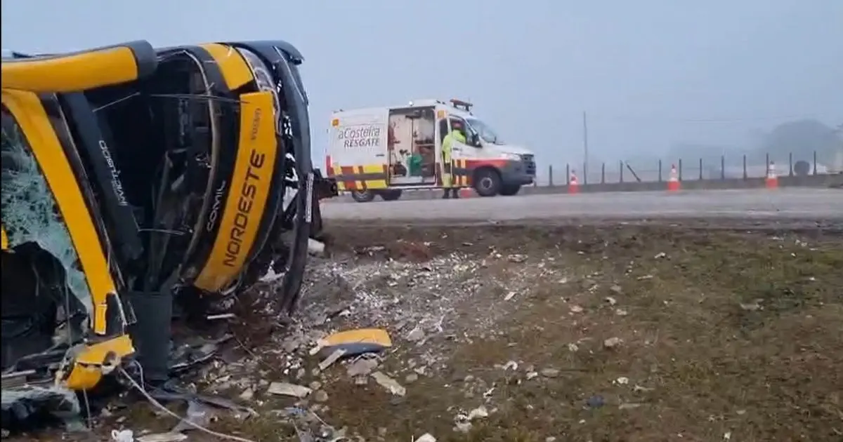 Veículo destruído após acidente e ambulância ao lado