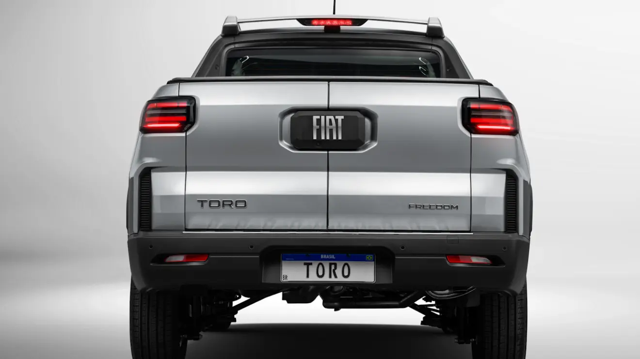 Traseira com lanternas acesas da Fiat Toro Freedom 2026 cinza