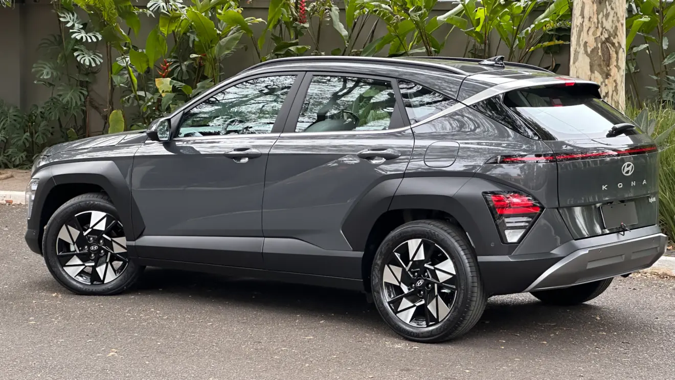 Hyundai Kona cinza parado de lateral com muro ao fundo