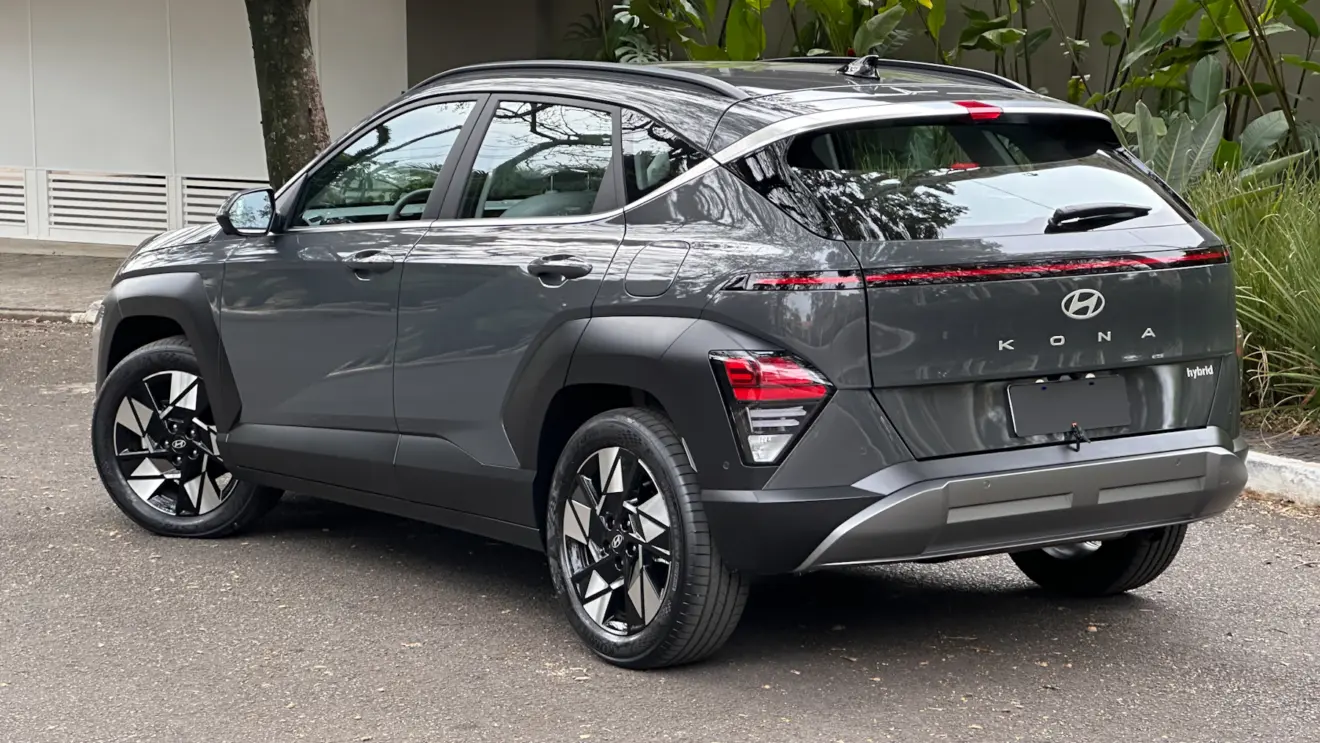 Hyundai Kona cinza parado de lateral com muro ao fundo