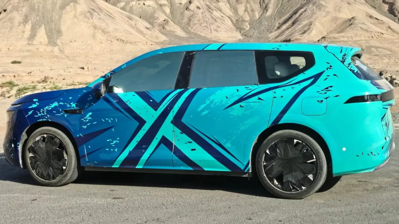 protótipo camuflado de azul de novo SUV da Nissan visto de lado
