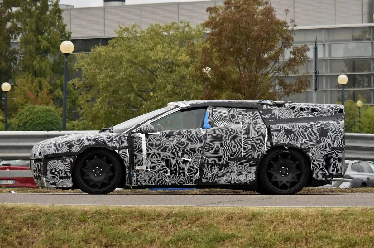 Ferrari EV camuflada de lateral andando na cidade