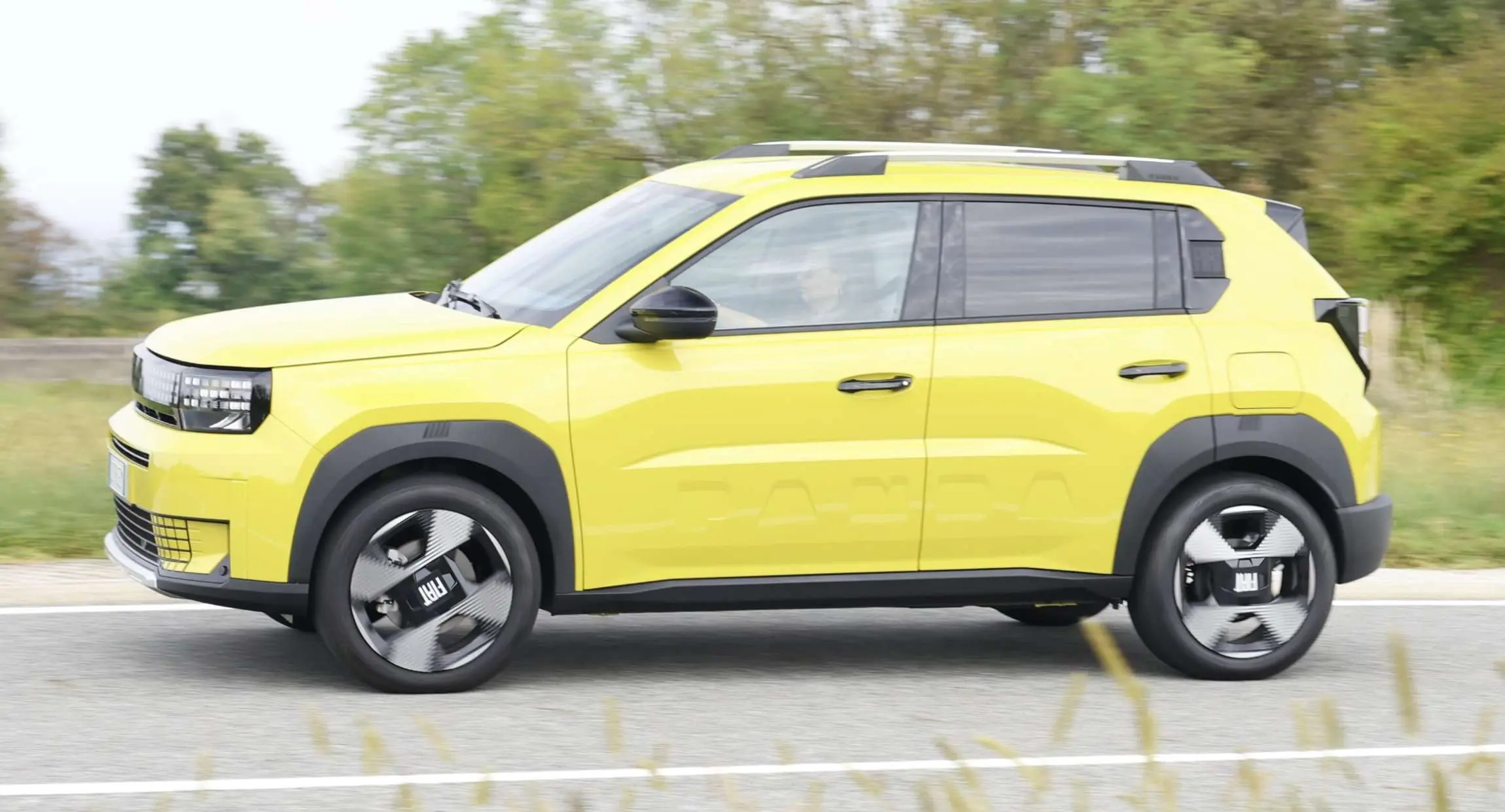 Fiat Grande Panda amarelo de lateral andando na pista