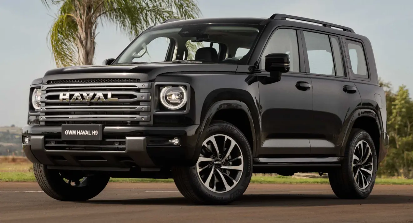 GWM Haval H9 preto parado de frente com árvore ao fundo usa motor a diesel 2.4 e câmbio automático de nove marchas