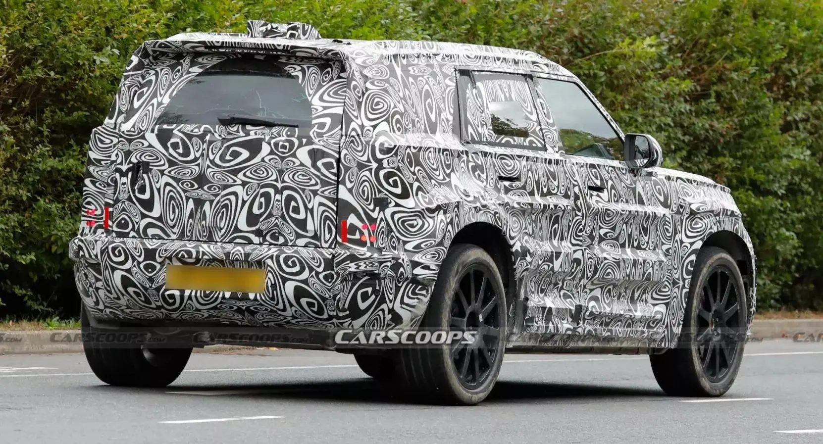 Jaguar Land Rover prepara novo SUV menor que o Defender de traseira andando na estrada