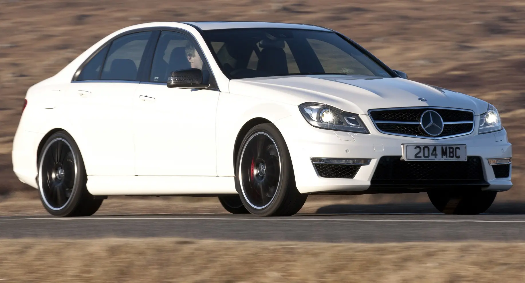 Mercedes-Benz C 63 AMG branco em movimento na estrada