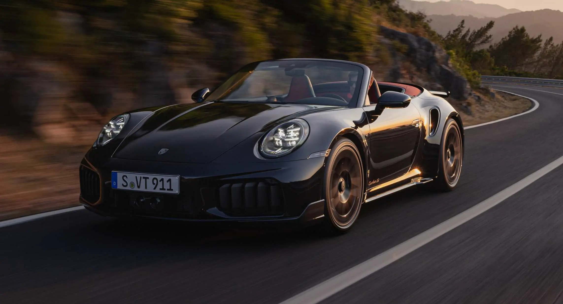 Novo Porsche 911 992.2 Turbo S Cabriolet preto de frente em movimento na estrada
