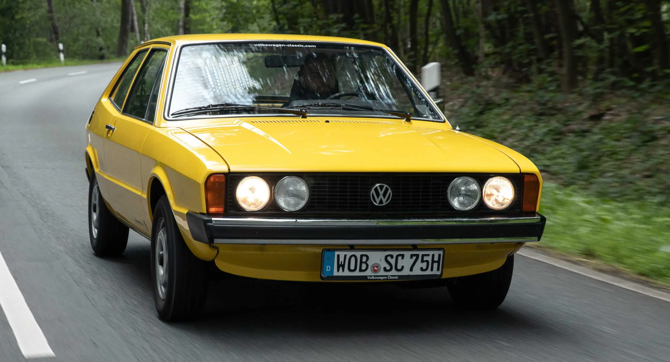 Volkswagen Scirocco amarelo de primeira geração em movimento na estrada