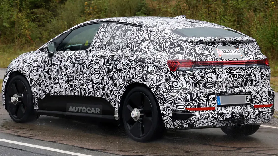 protótipo de novo SUV elétrico da Audi visto de trás, camuflado de preto e branco e com lanternas acesas